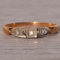 a gold ring with three diamonds on it