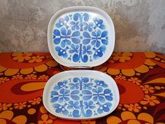 two blue and white plates sitting on top of a table