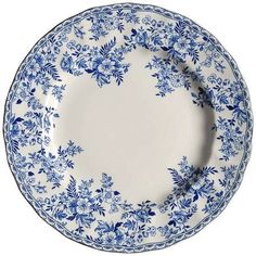 a blue and white plate with floral designs on the rim, set against a white background