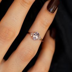 a close up of a person's hand with a ring on their finger and an oval shaped diamond in the middle