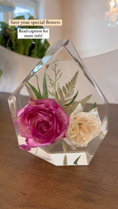 a glass vase with flowers in it sitting on a table