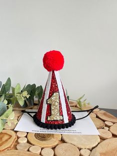 a red and white party hat sitting on top of a piece of wood