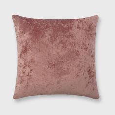 a pink velvet pillow on a white background