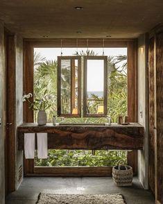 a bathroom with a large window, sink and rugs on the floor in front of it