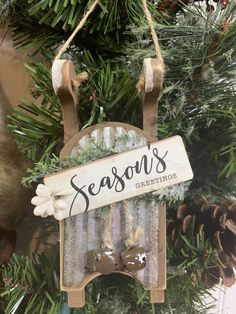 an ornament hanging from a christmas tree that says season's greetings