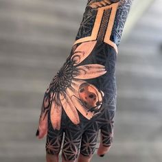 a person's hand with tattoos on it and flowers painted on the palm,