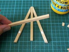 someone is making pops sticks out of matchesticks and glue on the table next to them