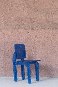 a blue chair sitting in front of a wall next to a red fire hydrant