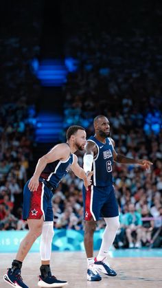 two men playing basketball in front of an audience