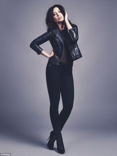 a woman in black is posing for the camera with her hand on her head and she's wearing a leather jacket