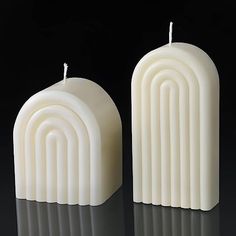 two white candles sitting next to each other