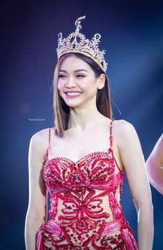 a woman in a red dress with a crown on her head