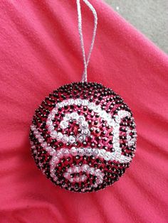 a beaded ornament hanging on a pink shirt