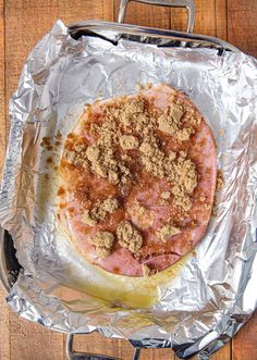 an uncooked pizza sitting on top of aluminum foil covered in spices and seasoning