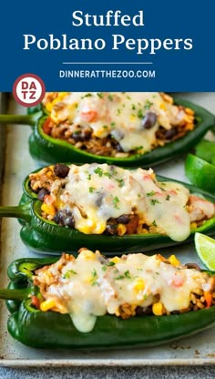 stuffed poblano peppers on a baking sheet with lime wedges in the background