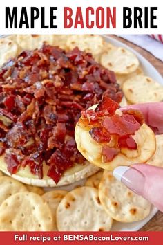 a person holding up a bacon brie on top of crackers