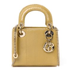 This is an authentic CHRISTIAN DIOR Snakeskin Mini Lady Dior in Beige. This delightful mini tote is crafted of beautifully textured snakeskin with matching leather top handles. This is complimented by polished light gold hardware including handle rings, large decorative eyelets and a hanging metal charms. The interior is a matching suede leather. Luxury Yellow Gold Leather Bags, Designer Yellow Gold Leather Bag, Designer Yellow Gold Bags For Everyday Luxury, Luxury Yellow Gold Top Handle Bag, Lady Dior Beige, Mini Lady Dior, Metal Charms, Mini Tote, Metal Charm