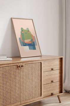 a wooden cabinet with an art print on it