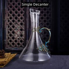 a glass decanter sitting on top of a table next to some napkins