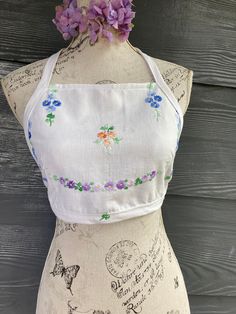 a top made from vintage embroidered linen halter ties unlined SIZE xs, small, m mannequin is a small Fitted Linen Halter Top, Fitted Linen Halter Neck Top, Embroidered Summer Crop Top, Fitted Embroidered Crop Top For Beach, Embroidered Fitted Crop Top For Summer, Fitted Embroidered Crop Top For Summer, Spring Embroidered Fitted Crop Top, Spring Fitted Embroidered Crop Top, Vintage Crop Top For Summer Festivals