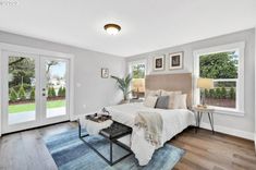 a bedroom with hardwood floors and white walls