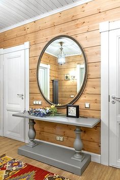 there is a mirror on the wall in this room with wood paneling and white doors