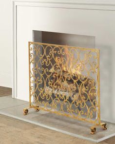 a fireplace with a gold fire place on top of it's sides and a white wall in the background