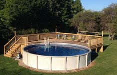 an above ground pool surrounded by decking and water features in the back yard area