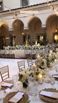 the tables are set up with candles and place settings for an elegant dinner or reception