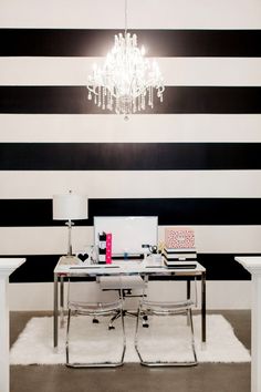 a room with black and white stripes on the wall, chandelier hanging from the ceiling