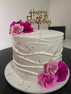 there is a white cake with pink flowers on it