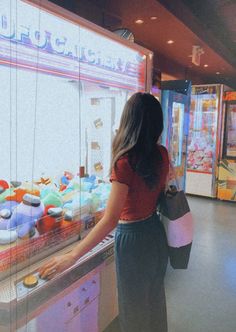 a woman standing in front of a vending machine filled with lots of donuts