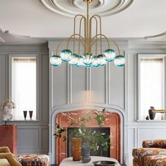 a living room filled with furniture and a fire place under a chandelier hanging from the ceiling