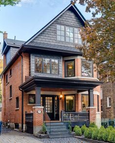 a large brick house with lots of windows on the second floor and stairs leading up to it's front door