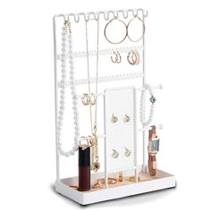 a white jewelry rack with several necklaces and rings hanging from it's sides