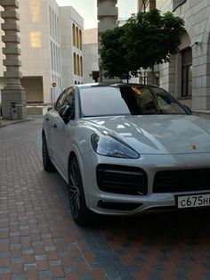 a white porsche cayen is parked on the street