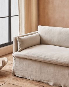 a white couch sitting in front of a window