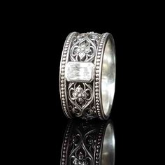 "The Valencia Wedding Ring design conjures up the Gothic traditions of this unique coastal region of Spain. The intricate carvings found in the Chapel of the Chalice were a particular inspiration. This ring is set with a 4x6mm cubic zirconia in a bezel mounting. The bezel is the most secure style of setting and its low profile is very comfortable to wear. CRAFTSMANSHIP and MATERIAL OPTIONS This design is rich in detail and the deeply carved pattern will last a lifetime. The detail runs around th Exquisite Carved Jewelry For Anniversary, Carved Sterling Silver Wedding Jewelry, Carved Sterling Silver Jewelry For Wedding, Ceremonial Silver Diamond Ring, Carved White Gold Jewelry For Anniversary, Luxury Carved Jewelry For Weddings, Heirloom Silver Jewelry With Carved Details, Heirloom Silver Carved Jewelry, Heirloom Style Carved Silver Jewelry