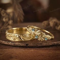 two gold wedding rings sitting on top of a wooden table