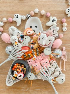 a table topped with lots of halloween treats and skeleton figurines on top of it