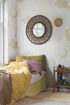 a bedroom with wallpaper and a mirror on the wall