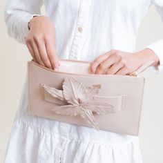 The STROLL is a slim leather clutch accented with a flower and makes accessorizing a natural art form. A hand loop makes this clutch easy to carry and ultra chic. Color: Nude 12"W x 8"H. (Interior capacity: small.) Leather Lined zip closure Clutch Imported Chic Clutch For Spring Season Gift, Chic Spring Clutch For Gift, Chic Spring Clutch As Gift, Spring Chic Pouch Clutch, Chic Spring Pouch Clutch, Elegant Spring Clutch With Removable Pouch, Feminine Evening Clutch For Spring, Flower-shaped Evening Clutch, Spring Evening Clutch With Removable Pouch