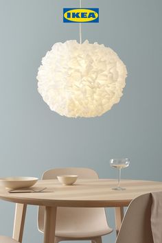 a light hanging over a dining room table with plates and cups on the table next to it