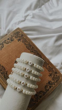 a book with pearls on it sitting on a bed next to a pair of socks