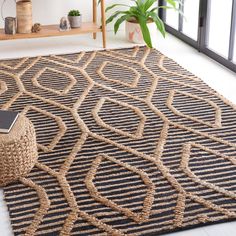 an area rug is shown with a phone on the floor and potted plant next to it