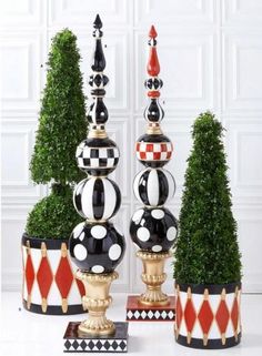 three potted plants with black and white polka dots on them, one in the center