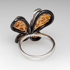 This exquisite butterfly ring is accented with seven (7), prong set, oval mixed cut natural spessartine garnet, two (2), prong set, round mixed cut natural spessartine garnet and one hundred forty-seven (147), bead/prong set, round brilliant cut diamonds. The ring measures 21.7mm at the top, rises 10.2mm above the finger, tapering to 3.5mm wide and 1.1mm thick at the base of the shank. This ring is currently a size 8.25. Spessartine Garnet, Butterfly Ring, Round Brilliant Cut Diamond, Brilliant Cut Diamond, Round Brilliant, Prong Setting, Garnet, Diamonds, White Gold