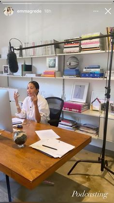 a woman sitting at a desk talking on the phone