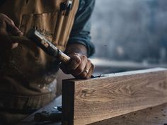 a person using a hammer to cut wood