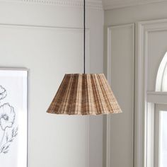 a lamp hanging from the ceiling in a living room with white walls and flooring